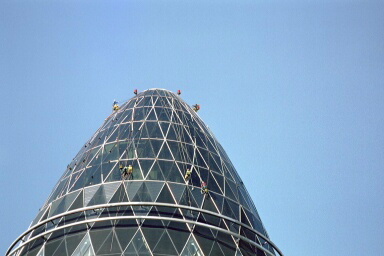 Industriekletterer von ZITRAS bei Wartungs-, Bau- oder Reinigungsarbeiten an der gläsernen Fassade eines Gebäudes mit dreieckigem Dach.